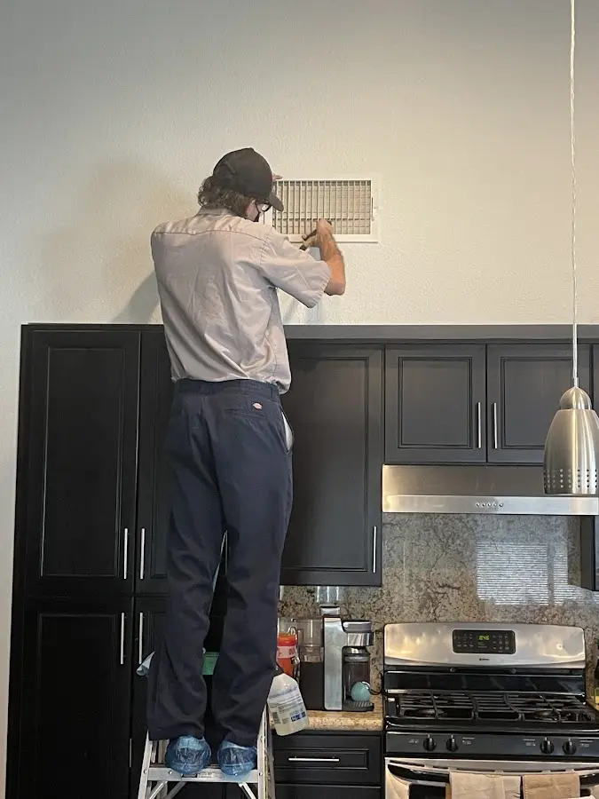 Technician inspecting an air vent during HVAC service in Menlo Park